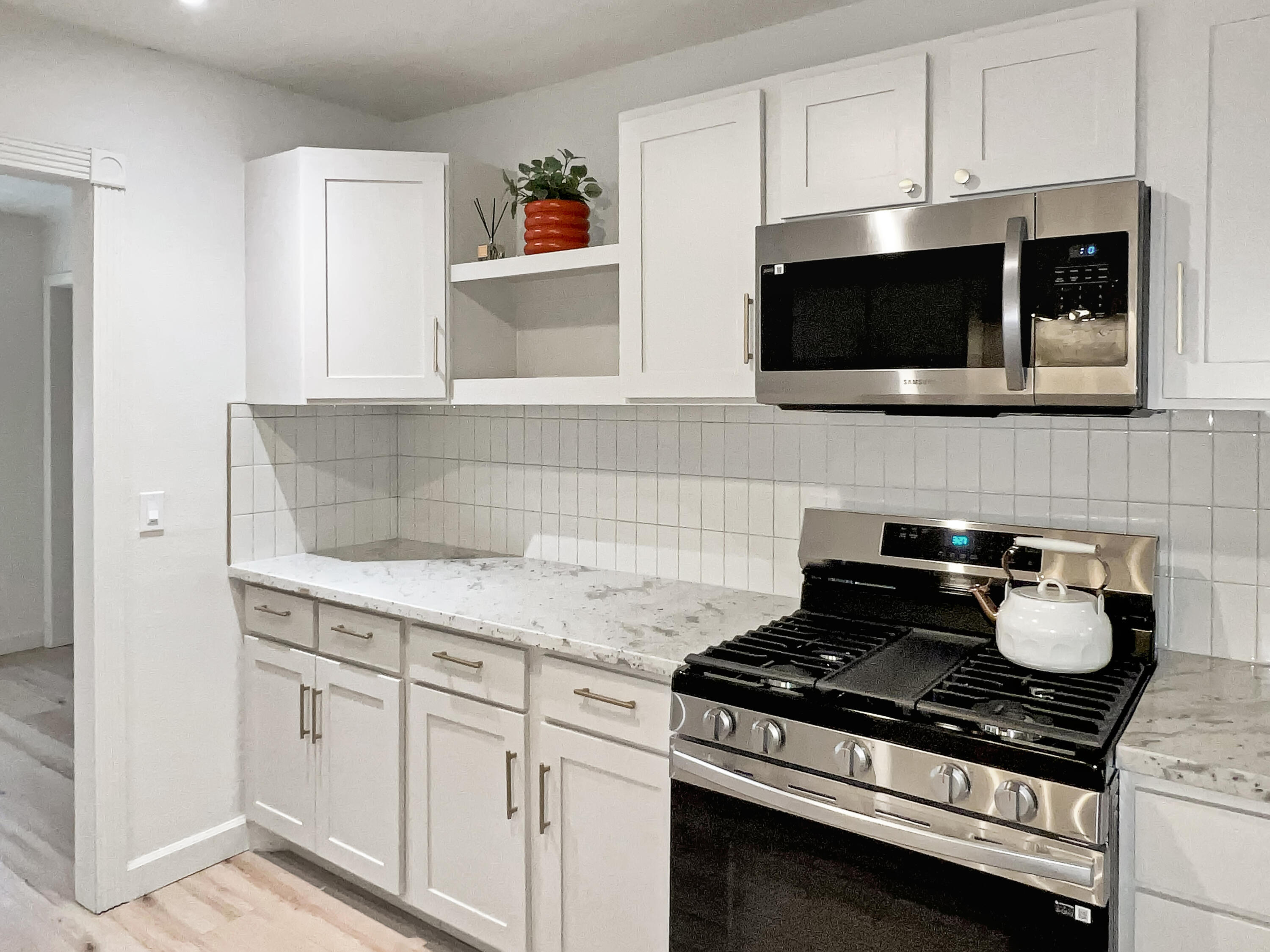 3827 52nd Street Lubbock, TX 79413 - Photo 7 of 24 a kitchen with stainless steel appliances a stove a microwave and cabinets