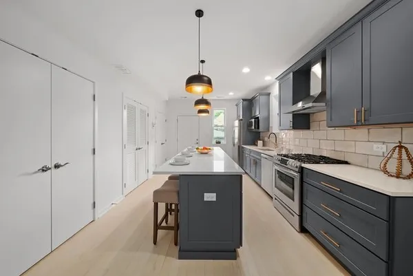 a kitchen with stainless steel appliances granite countertop a stove a sink and a refrigerator