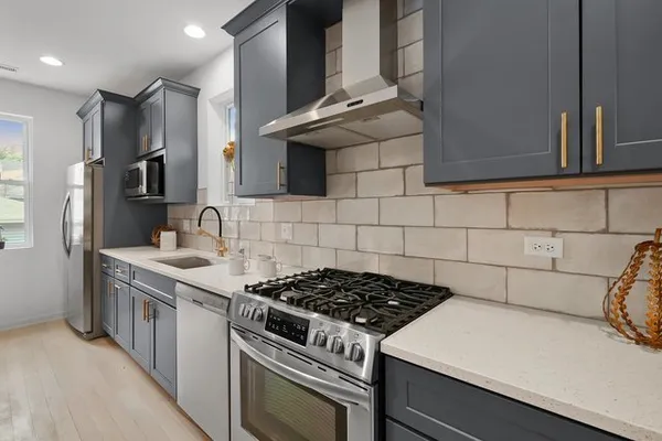 a kitchen with stainless steel appliances a stove a sink and a refrigerator