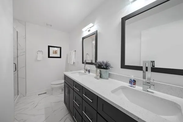 a bathroom with double sink and a mirror