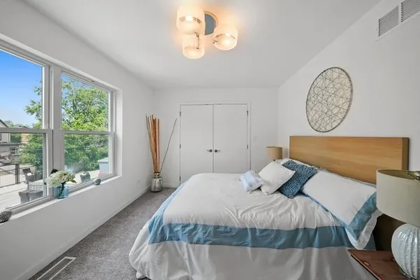 a bedroom with a bed and a large window