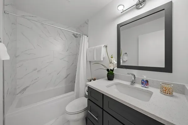 a bathroom with a sink a toilet and shower