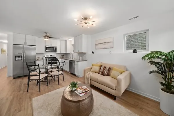 a living room with furniture kitchen and a table