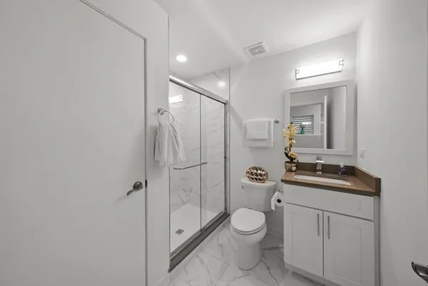 a bathroom with a toilet a sink and shower