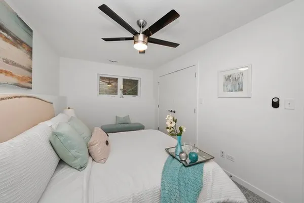 a bedroom with a bed and a potted plant
