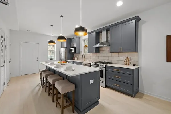a kitchen with a sink a stove and chairs