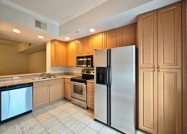 a kitchen with stainless steel appliances granite countertop a refrigerator and a stove top oven