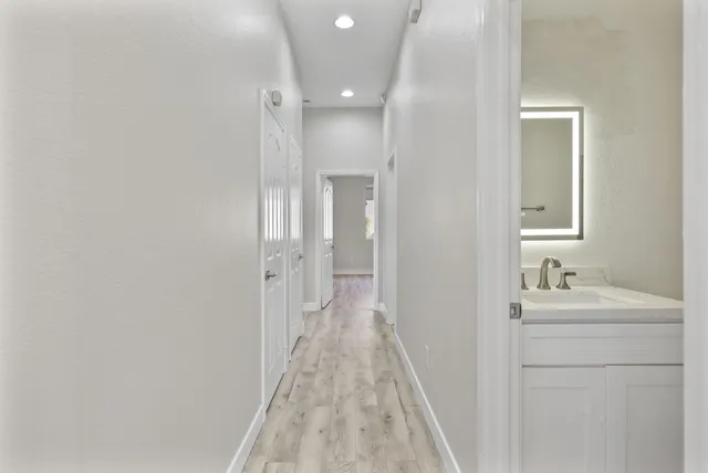 a bathroom with a white bath tub a mirror and a sink