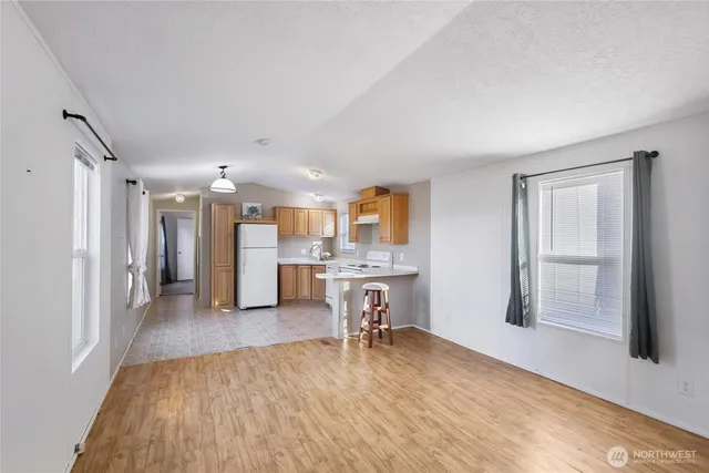 a view of a livingroom with a dinning area hardwood floor and a kitchen