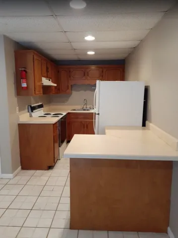 a large kitchen with stainless steel appliances a sink a stove and a refrigerator