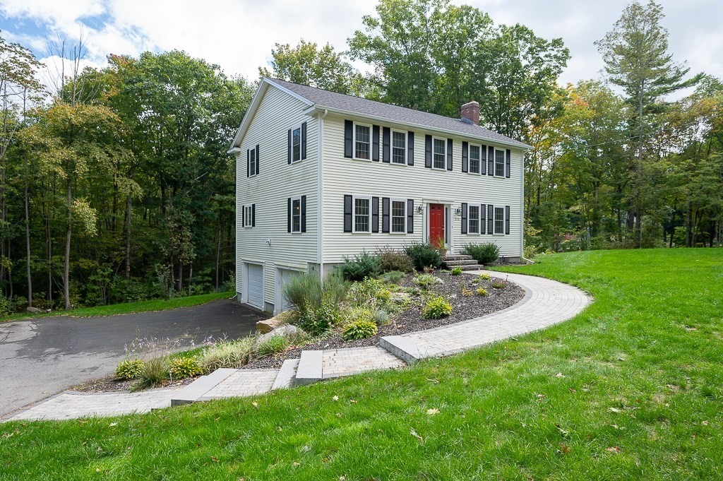 a front view of a house with a yard and trees