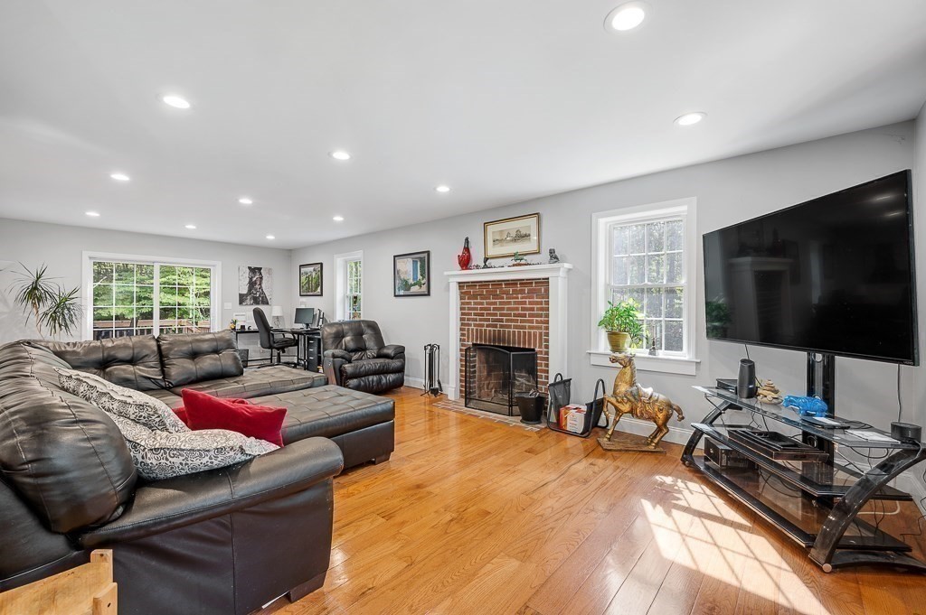173 Podunk Road Sturbridge, MA 01566 - Photo 13 of 40 a living room with furniture a flat screen tv and a fireplace