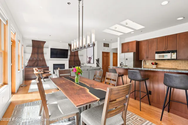 a view of a dining room with furniture a rug and wooden floor