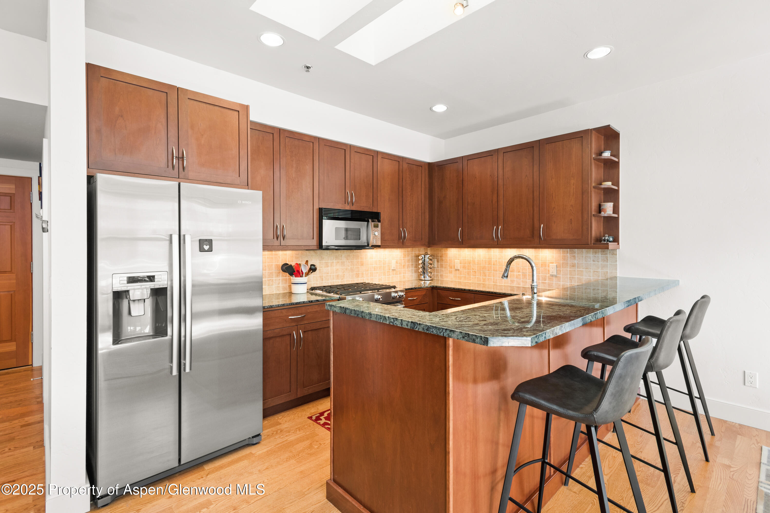 227 Midland Avenue, Unit 24 Basalt, CO 81621 - Photo 3 of 12 a kitchen with kitchen island a counter top space appliances and a refrigerator