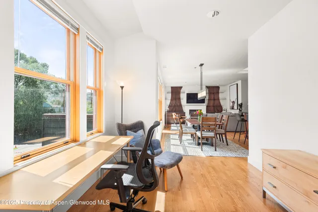 a living room filled with furniture and large windows