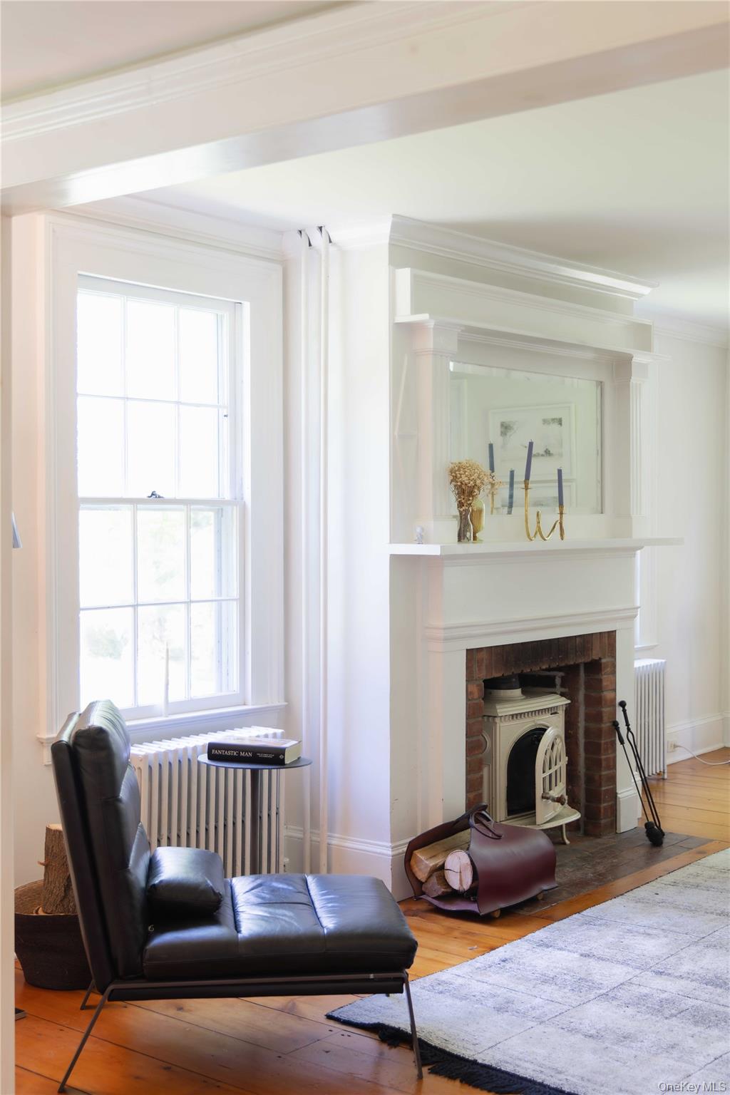 210 Middle Road Hudson, NY 12534 - Photo 20 of 42 Hardwood flooring extending through the room, complemented by a fireplace with a detailed white mantel