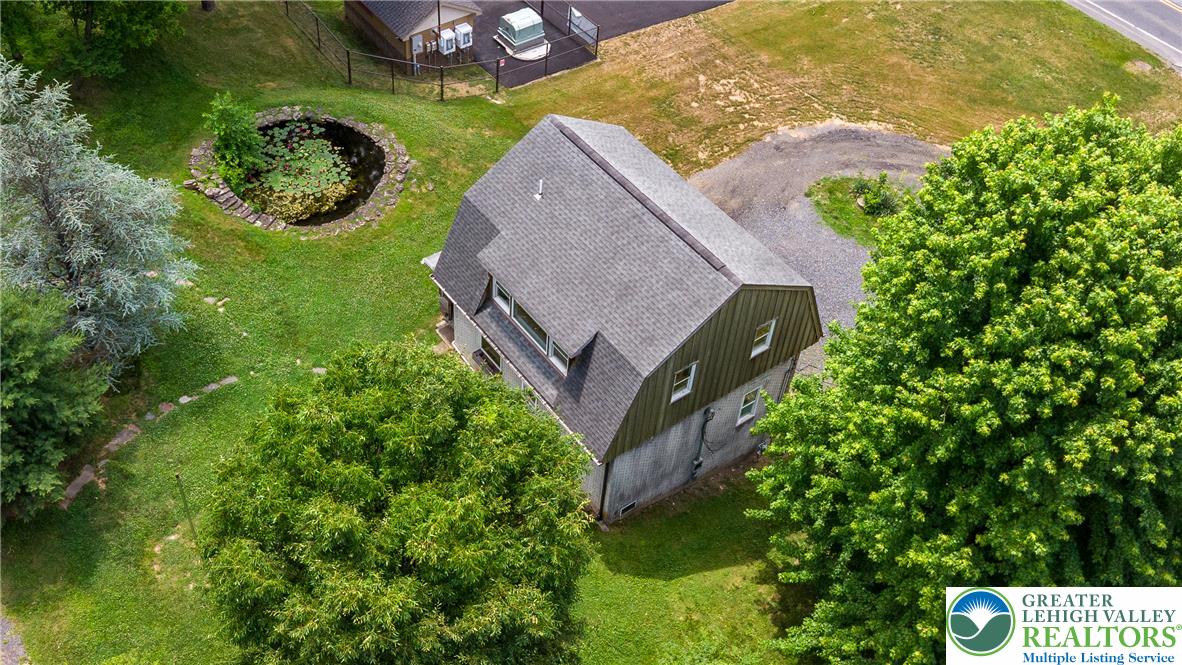 1815 Leithsville Road Hellertown, PA 18055 - Photo 34 of 38 Aerial view showcasing a rustic barn with abundant greenery and a tranquil pond feature.