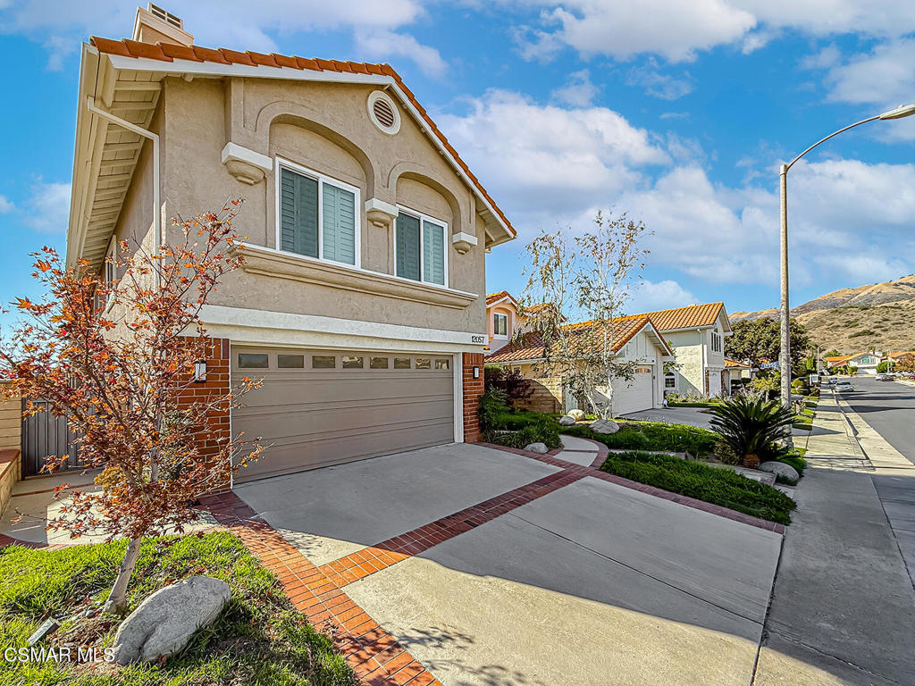 12057 Falcon Crest Way Porter Ranch, CA 91326 - Photo 3 of 86 a front view of a house with a yard and garage