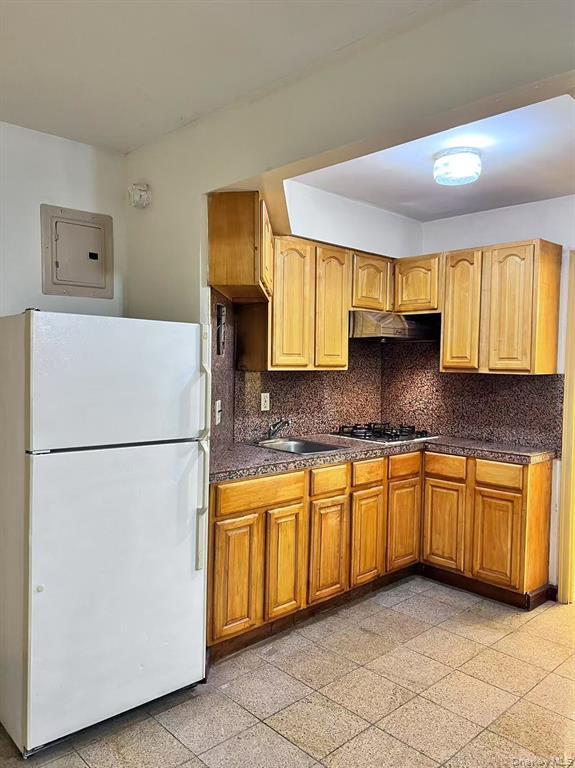 37-30 103rd Street, Unit 2B Queens, NY 11368 - Photo 4 of 8 a kitchen with granite countertop cabinets sink and white appliances