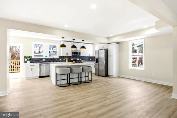 a kitchen with stainless steel appliances kitchen island wooden cabinets and a stove