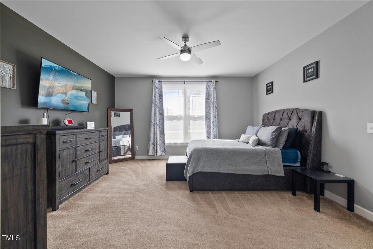 1005 Bellewood Farms Road Raleigh, NC 27603 - Photo 14 of 61 a spacious bedroom with a bed and a flat screen tv