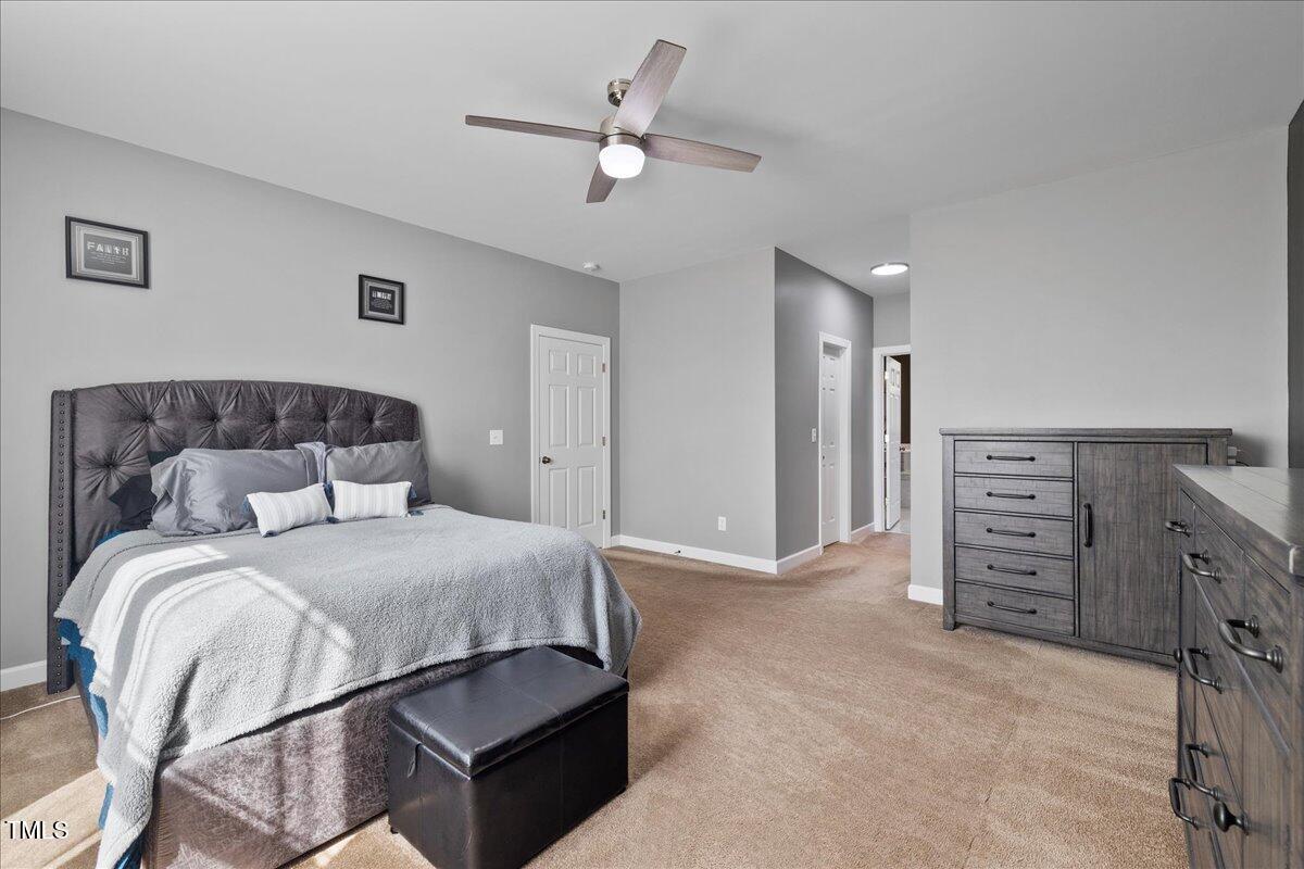 1005 Bellewood Farms Road Raleigh, NC 27603 - Photo 15 of 61 a bedroom with a bed and a chandelier