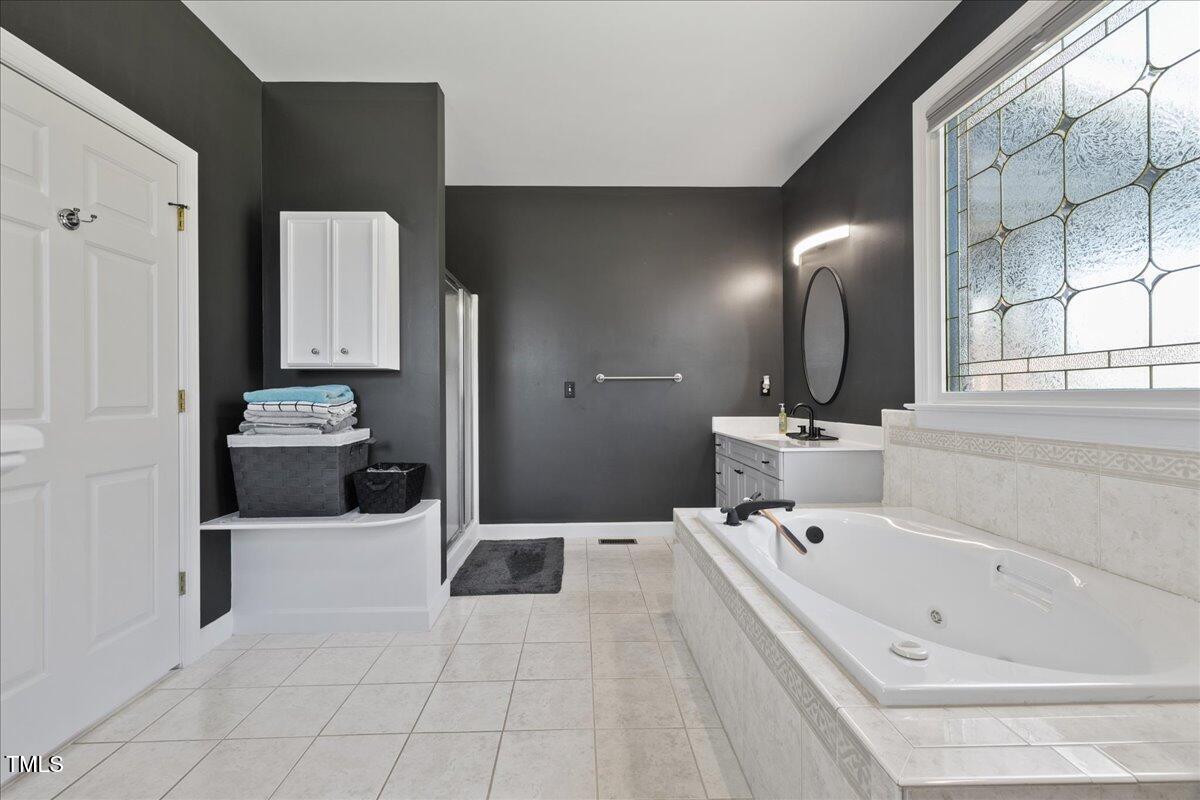 1005 Bellewood Farms Road Raleigh, NC 27603 - Photo 19 of 61 a bathroom with a tub sink and mirror