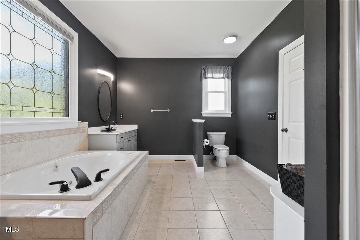 1005 Bellewood Farms Road Raleigh, NC 27603 - Photo 20 of 61 a bathroom with a sink and mirror