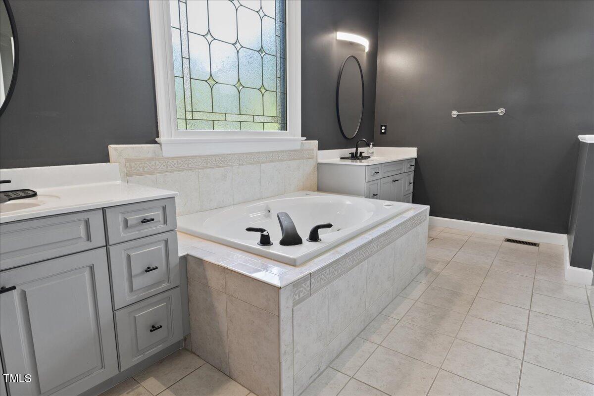 1005 Bellewood Farms Road Raleigh, NC 27603 - Photo 21 of 61 a bathroom with a sink vanity and a mirror