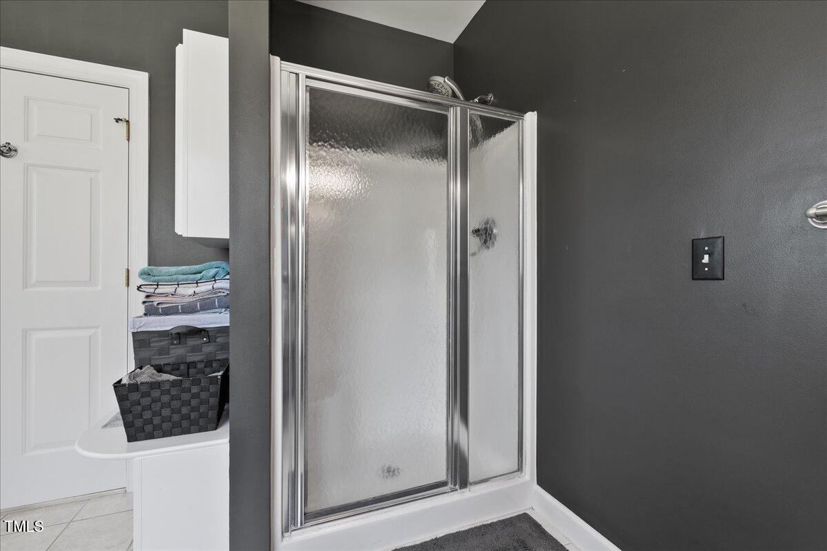 1005 Bellewood Farms Road Raleigh, NC 27603 - Photo 22 of 61 a bathroom with a glass shower door and a sink