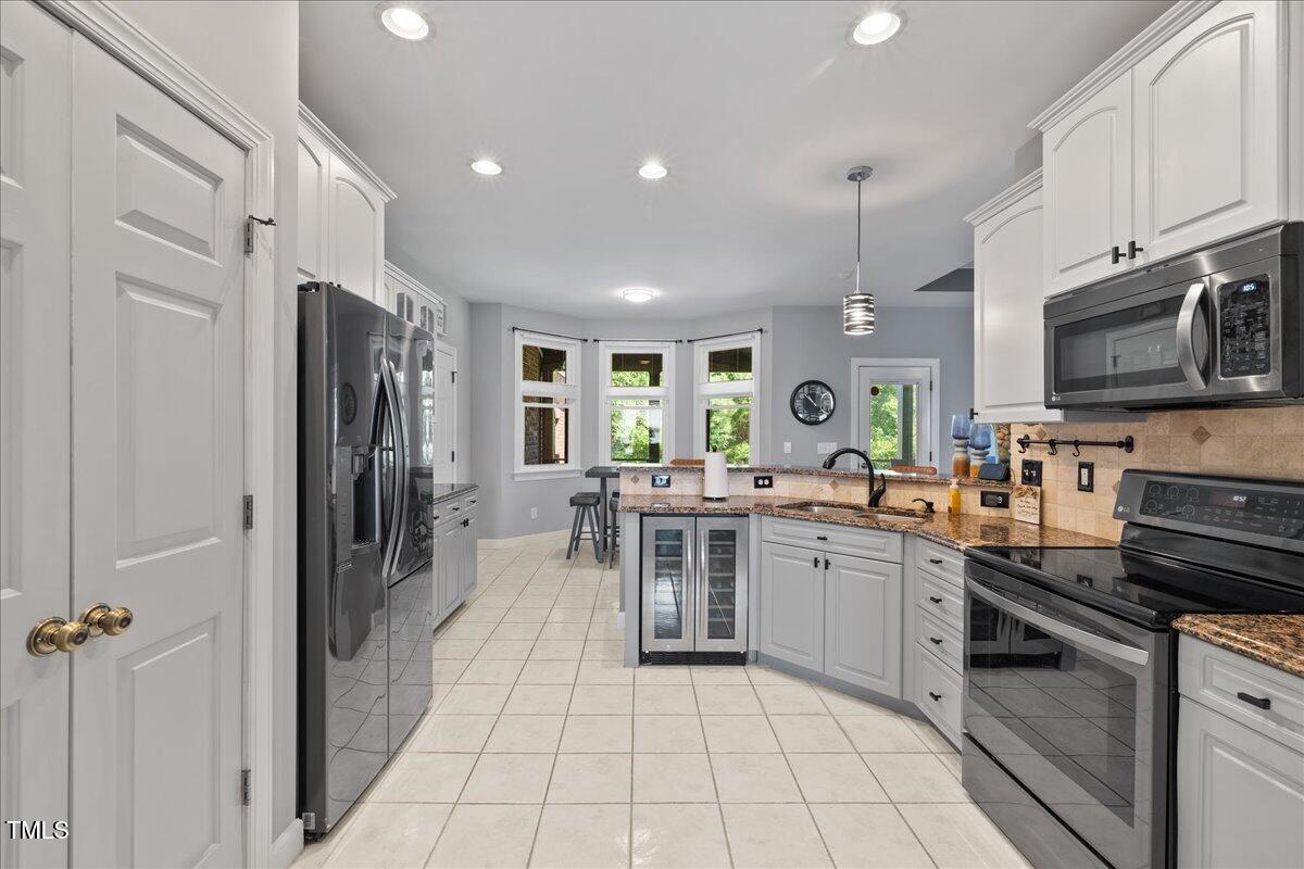 1005 Bellewood Farms Road Raleigh, NC 27603 - Photo 33 of 61 a kitchen with a sink stainless steel appliances and cabinets