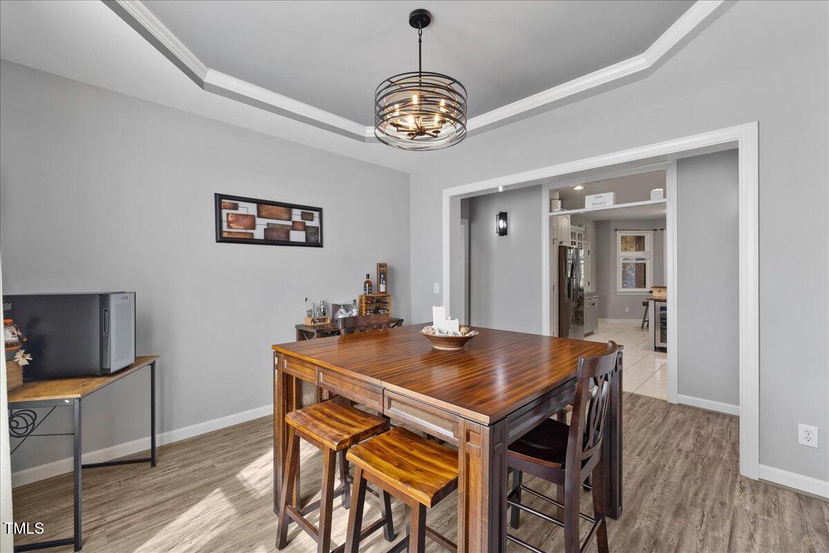 1005 Bellewood Farms Road Raleigh, NC 27603 - Photo 35 of 61 a view of a dining room with furniture wooden floor and a chandelier