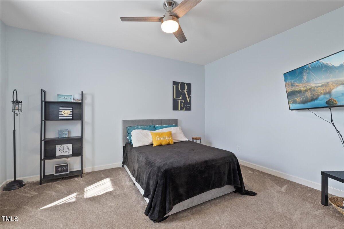 1005 Bellewood Farms Road Raleigh, NC 27603 - Photo 38 of 61 a bedroom with a bed and a chandelier