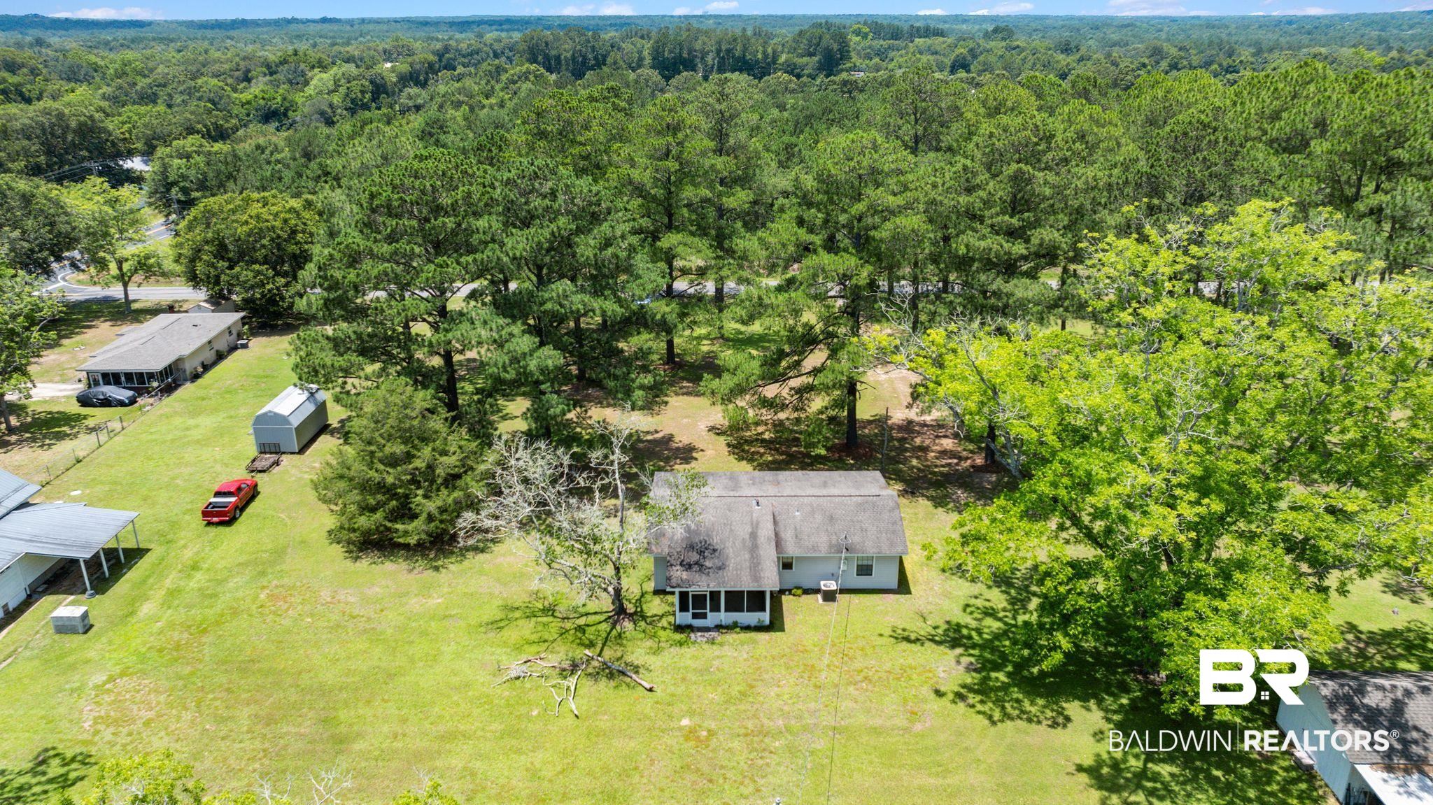 20540 Lacey Road Silverhill, AL 36576 - Photo 28 of 40 Expansive green landscape with mature trees and a detached shed