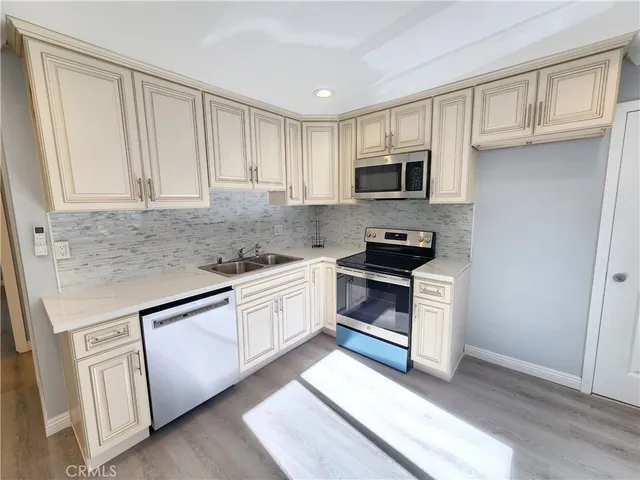 a kitchen with granite countertop white cabinets and stainless steel appliances