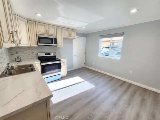 a kitchen with stainless steel appliances a stove a sink a microwave and cabinets