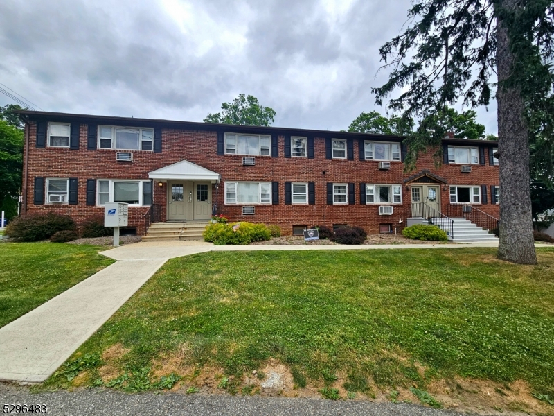 201 Vail Street, Unit 1B Hackettstown, NJ 07840 - Photo 2 of 12 a front view of a house with a yard table and chairs