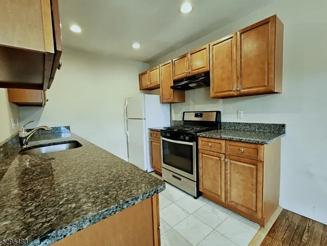 a kitchen with stainless steel appliances granite countertop a sink stove and microwave