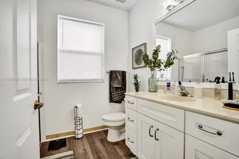 a spacious bathroom with a toilet a sink and a mirror