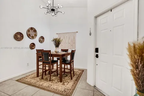 a view of a dining room and chandelier fan and wooden floor