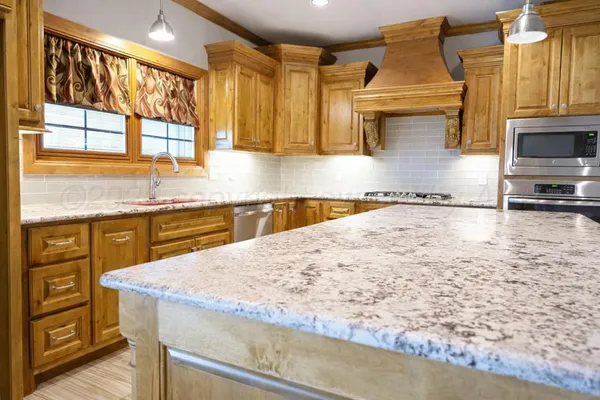 a kitchen with stainless steel appliances granite countertop a sink a stove and cabinets