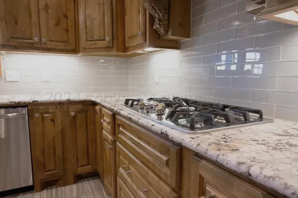 a kitchen with granite countertop a stove and cabinets
