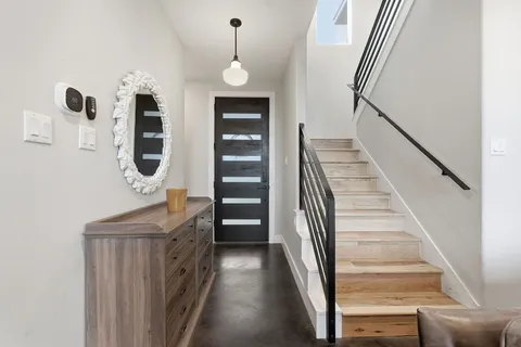 a view of staircase with lots of frames on wall and a wooden floor
