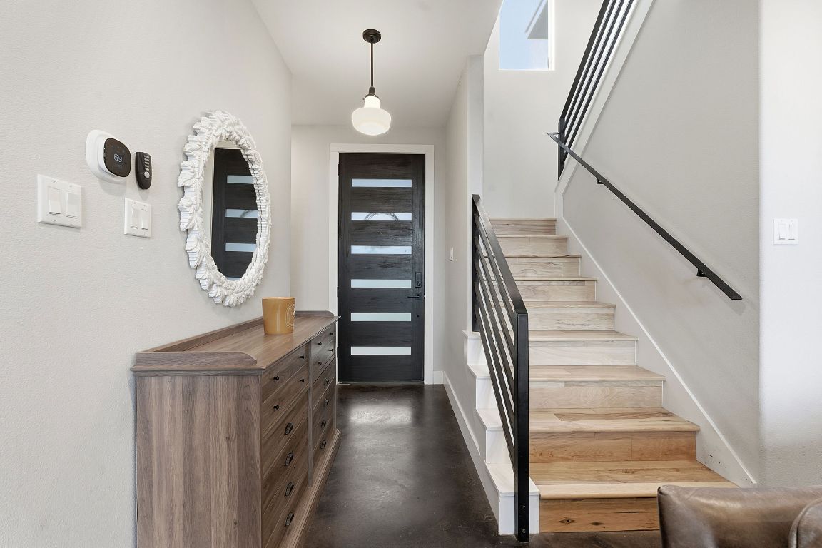10012 Janet Loop Dripping Springs, TX 78620 - Photo 12 of 38 a view of staircase with lots of frames on wall and a wooden floor