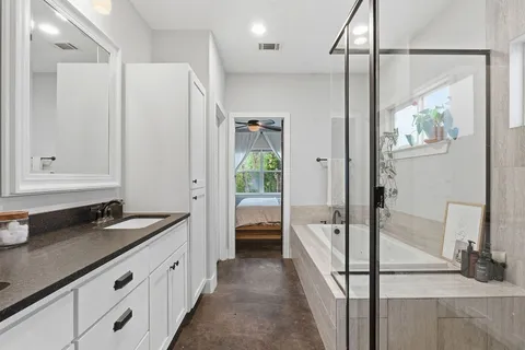 a spacious bathroom with a granite countertop sink a mirror and a shower