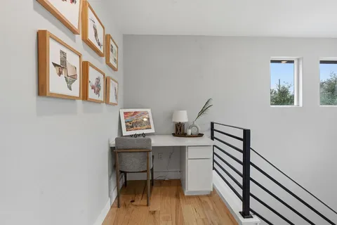 a view of a workspace with furniture and wooden floor