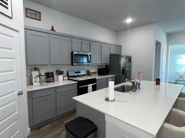 a kitchen with a sink a stove a refrigerator and cabinets