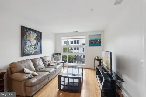 a living room with furniture a flat screen tv and a window