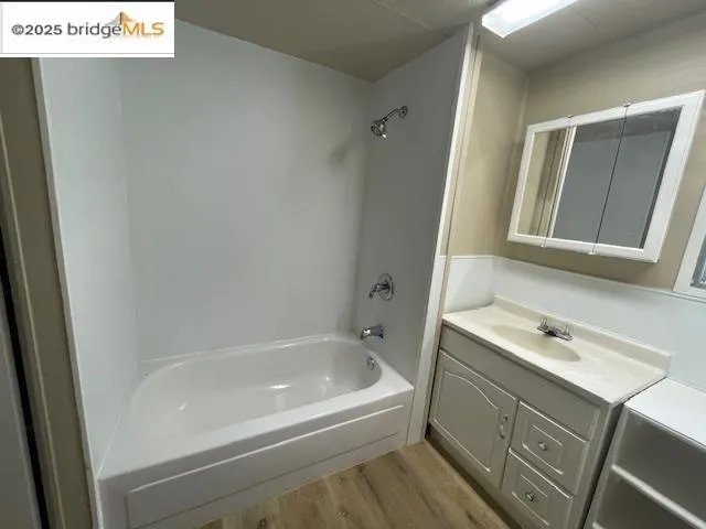 a bathroom with a tub sink and mirror