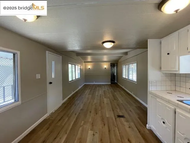 a view of hallway with window and wooden floor
